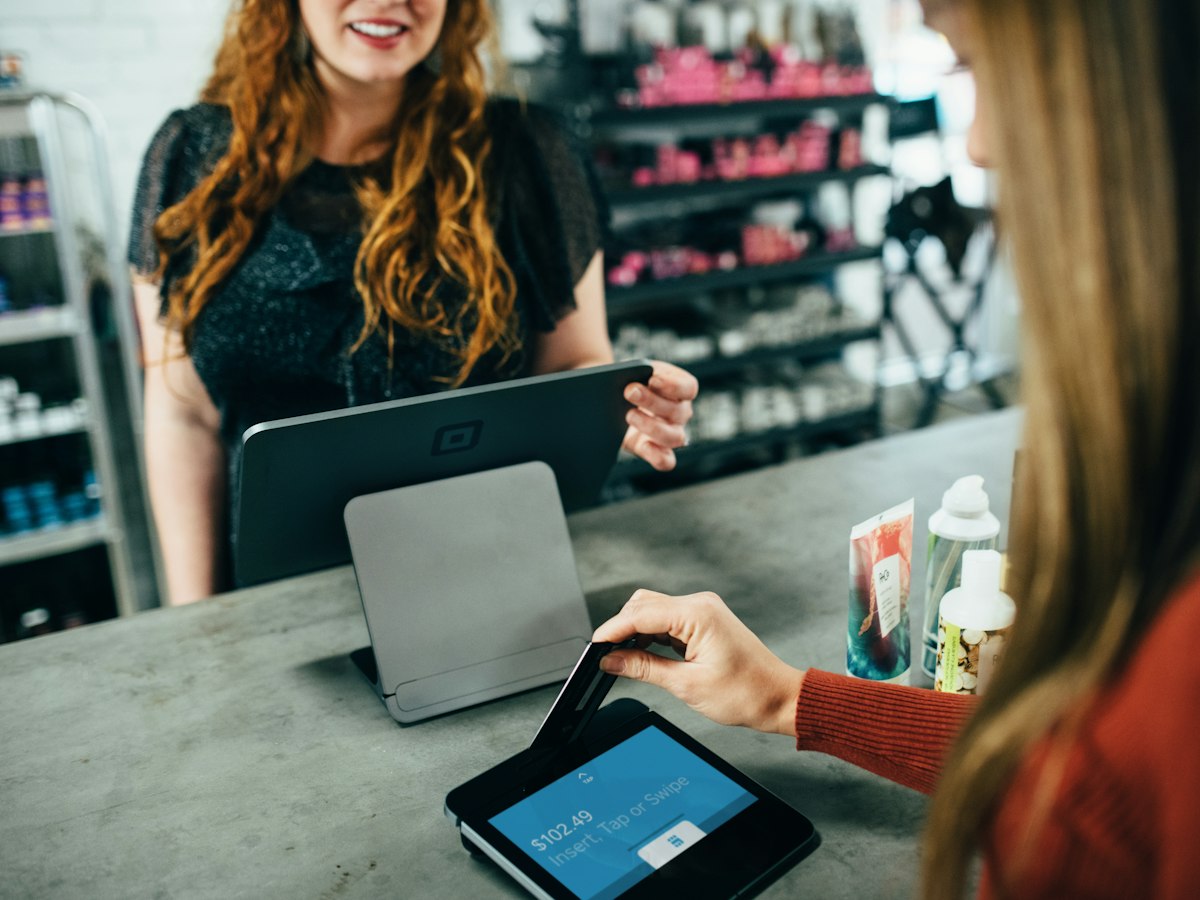 Shop owner taking a card payment in store